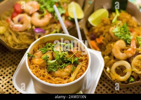 Immagine closeup del cibo di strada notturno della Thailandia con gamberi e noodle servito in una ciotola Foto Stock
