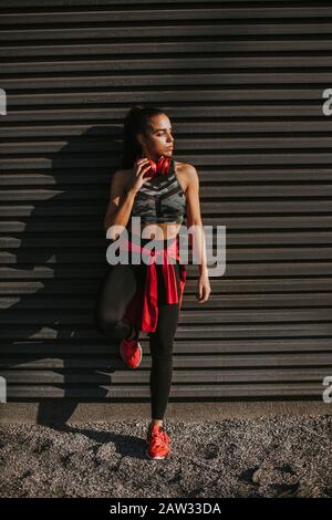 Bella giovane donna prende una pausa dopo la corsa nella zona urbana Foto Stock