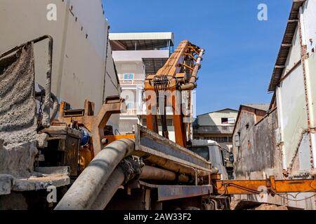 Un piccolo macchinista di pile è istituito sul sito di costruzione di un nuovo edificio su un lotto vacante nel centro della città di Kampong Cham, Cambogia. Foto Stock