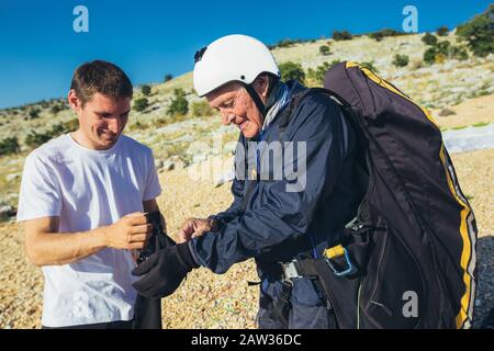 Il parapendio senior a terra prepare volare. Foto Stock