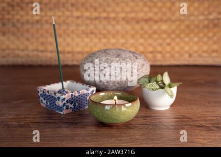 Decorazione con incenso bruciante, candela, pietra e pianta fresca. Yoga, attrezzatura da meditazione. Foto Stock