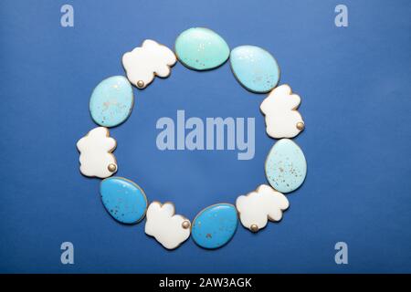 Biscotti di Pasqua su un piatto su uno sfondo blu. Coniglietto Di Pasqua. Uova di Pasqua. Nella forma di un telaio. Foto Stock