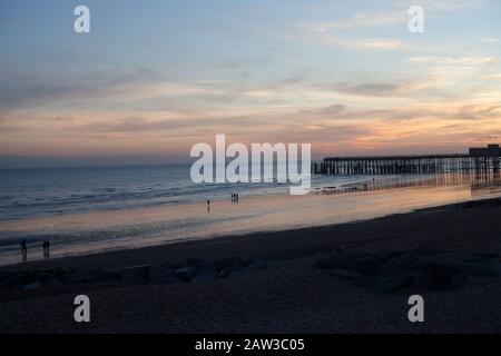 Tramonto su Hastings Beach and Pier, Hastings, East Sussex, Regno Unito Foto Stock