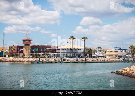 Vilamoura, Portogallo - 1° maggio 2018: Vista dell'ingresso al porto turistico dove le persone camminano in una giornata primaverile Foto Stock