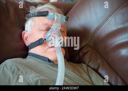 Stanco uomo senior pan con una apnea nel sonno la macchina Foto Stock