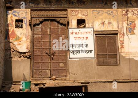 India, Rajasthan, Shekhawati, Mandawa, Akram Ka Haveli, resti di antiche mura dipinte storiche intorno alla vecchia porta della casa di legno Foto Stock