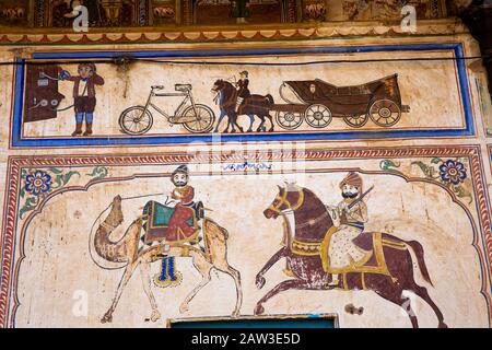 India, Rajasthan, Shekhawati, Mandawa, Binsidhar Newatia Haveli, murale di trasporto sulle pareti esterne della casa che illustra la vita nel 1921 quando fu costruita Foto Stock