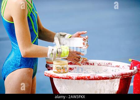 ragazza ginnastica in ginnastica impugnature spalmando gym gesso Foto Stock