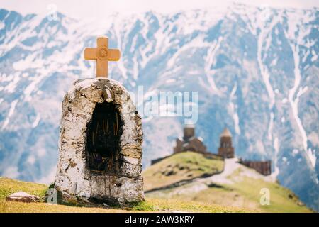 Stepantsminda, Gergeti, Georgia. Croce Su Pietre Su Sfondo Montagne Vicino A Gergeti Trinità Tsminda Sameba Chiesa. Foto Stock