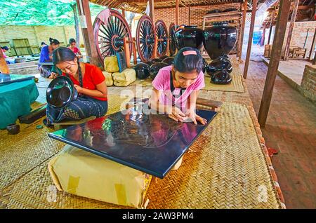 Bagan, MYANMAR - 25 FEBBRAIO 2018: Teen artigiani di lacceria lavoro di laboratorio con stoviglie e pannelli laccati, facendo modelli birmani tradizionali Foto Stock