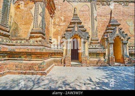 L'antica parete del Tempio di Htilominlo con strutture porta in rilievo complesso, decorato con motivi e motivi fine, Bagan, Myanmar Foto Stock