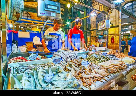 Jerez, SPAGNA - 20 SETTEMBRE 2019: I venditori tagliano e impachono il pesce fresco in stalla del Mercado Central de Abastos (mercato di Sentral Abastos), a Septemb Foto Stock