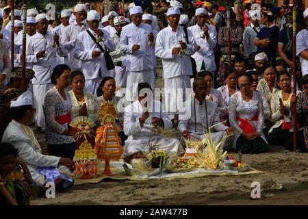 Sacerdote indù balinese che prega durante la cerimonia di Melasti a Parangkusumo Beach, domenica 3 marzo 2019. Portano offerte che contengono frutta, fiori e incenso per l'offerta. Melasti è auto pulizia prima di entrare Nel Nyepi Day o Silent Day ed è di solito fatto in acqua fonte come il mare o lago. Credono facendo Melasti tutti i tratti cattivi dell'anima e del corpo. Foto Stock