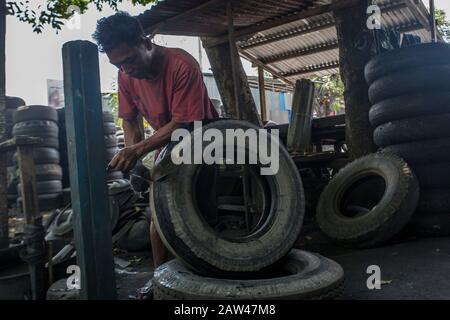 I lavoratori hanno visto la produzione di contenitori di rifiuti realizzati con rifiuti di pneumatici usati presso il laboratorio 'Small and Medium Enterprise' (UKM) a Palu, nel Sulawesi Centrale, in Indonesia, giovedì 15 agosto 2019. Vari oggetti di artigianato provenienti da rifiuti di pneumatici usati sono venduti a prezzi variabili tra 75 - 200 mila Rupiah. I rifiuti di pneumatici usati possono essere utilizzati per realizzare beni di valore economico come banchi, tavoli o trasformati in polvere di gomma. Foto Stock