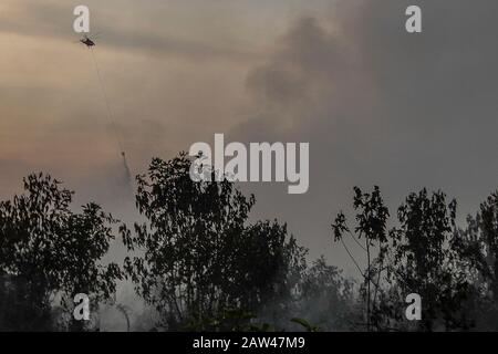 Un bombardamento d'acqua elicotteri cercare di spegnere incendi di terra nel villaggio di Rimbo Panjang, Kampar Regency, Riau, 6 ottobre 2019. Foto Stock