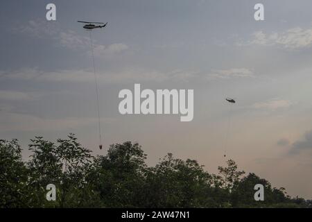 Un bombardamento d'acqua elicotteri cercare di spegnere incendi di terra nel villaggio di Rimbo Panjang, Kampar Regency, Riau, 6 ottobre 2019. Foto Stock