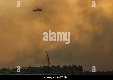 Un bombardamento d'acqua elicotteri cercare di spegnere incendi di terra nel villaggio di Rimbo Panjang, Kampar Regency, Riau, 6 ottobre 2019. Foto Stock