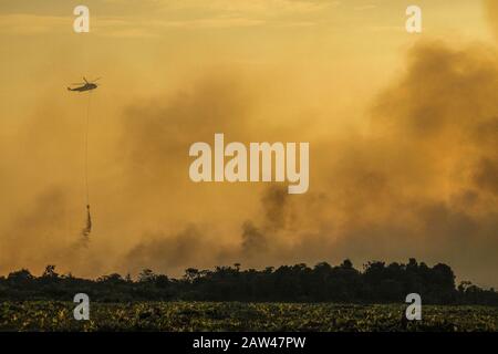 Un bombardamento d'acqua elicotteri cercare di spegnere incendi di terra nel villaggio di Rimbo Panjang, Kampar Regency, Riau, 6 ottobre 2019. Foto Stock