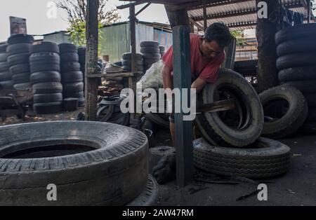 I lavoratori hanno visto la produzione di contenitori di rifiuti realizzati con rifiuti di pneumatici usati presso il laboratorio 'Small and Medium Enterprise' (UKM) a Palu, nel Sulawesi Centrale, in Indonesia, giovedì 15 agosto 2019. Vari oggetti di artigianato provenienti da rifiuti di pneumatici usati sono venduti a prezzi variabili tra 75 - 200 mila Rupiah. I rifiuti di pneumatici usati possono essere utilizzati per realizzare beni di valore economico come banchi, tavoli o trasformati in polvere di gomma. Foto Stock