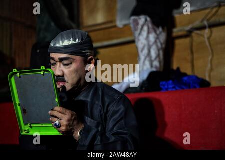 Un artista sta mettendo sul trucco durante la rappresentazione dell'arte del teatro giavanese denominata Ketoprak Tobong Kelana Bakti a Yogyakarta, Indonesia, venerdì 25 ottobre 2019. Ketoprak Tobong è un teatro tradizionale giavanese, con dialogo, monologhi e musica gamelana. Questa arte è molto rara e quasi estinta. Ketoprak Tobong Kelana Bhakti è uno degli ultimi trovatori di teatro nomade rimasti e si è esibito in diversi paesi del mondo. Foto Stock