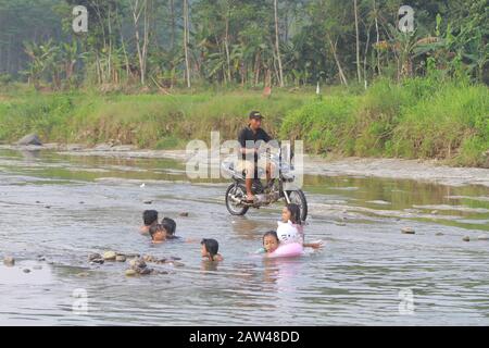 I bambini si vedono giocare in acqua del fiume Sari montagna, Bogor Regency, West Java, Mercoledì 03 luglio 2019. I residenti utilizzano il fiume Sari di montagna per bagnarsi e lavare i vestiti a causa della siccità e dell'estate. Foto Stock