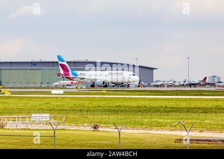 Stoccarda, Germania - 29 aprile 2017: Aeromobile Airbus A319 da Eurowings a terra (aeroporto di Stoccarda) sulla strada per il decollo - prato verde con fenc Foto Stock