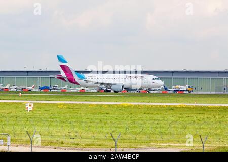 Stoccarda, Germania - 29 aprile 2017: Aeromobile Airbus A319 da Eurowings a terra (aeroporto di Stoccarda) sulla strada per il decollo - prato verde con fenc Foto Stock