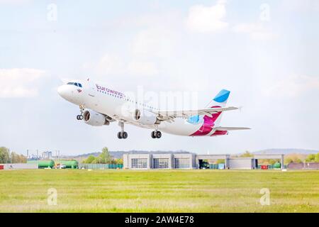 Stoccarda, Germania - 29 aprile 2017: Aeromobile Airbus A320-100 dall'approccio di atterraggio Eurowings / dopo il decollo - aeroporto di Stoccarda, cielo con nuvole dentro Foto Stock