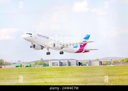 Stoccarda, Germania - 29 aprile 2017: Aeromobile Airbus A320-100 dall'approccio di atterraggio Eurowings / dopo il decollo - aeroporto di Stoccarda, cielo con nuvole dentro Foto Stock