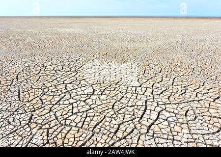 Paesaggio desolato con massa fessurato in riva al mare. Marrone, beige, marrone chiaro e grigio colorato. Concetto di riscaldamento globale. Foto Stock