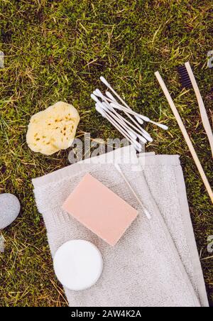 Concetto di prodotti naturali e biodegradabili. Vari prodotti da bagno su muschio verde naturale all'aperto. Vista a disposizione piatta con molto spazio di copia. Fib di bambù Foto Stock