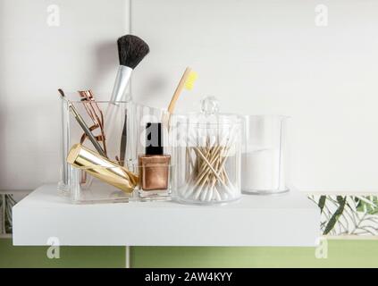 Creare il concetto organizzativo dei prodotti. Prodotti di bellezza in scatola contenitore organizer su scaffale minimalista in modo ordinato. Tamponi di cotone impilati, puntali Q. Foto Stock