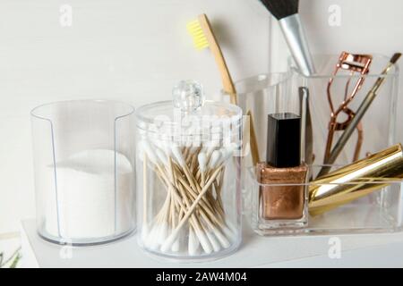 Creare il concetto organizzativo dei prodotti. Prodotti di bellezza in scatola contenitore organizer su scaffale minimalista in modo ordinato. Tamponi di cotone impilati, puntali Q. Foto Stock