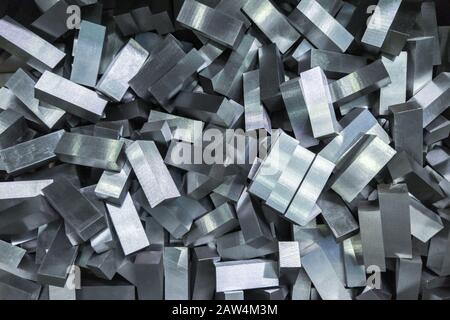 una pila di blocchi in acciaio lucido sfaccettato - primo piano a telaio completo con messa a fuoco selettiva, vista direttamente dall'alto Foto Stock