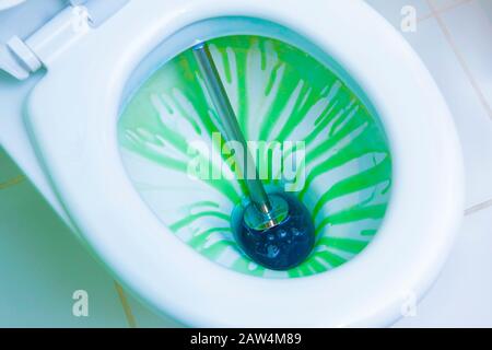 Disinfezione della toilette, con l'uso di colorati liquidi antibatterici e strumenti di pulizia. Vista ravvicinata. Foto Stock