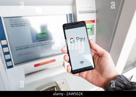 Wroclaw, Polonia - Nov 06, 2019: Uomo con smartphone con Google Pay logo. Google Pay è portafoglio elettronico sviluppato da Google. Foto Stock