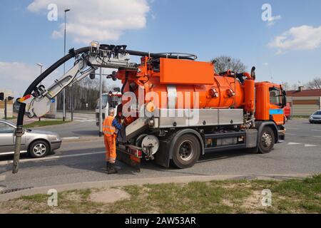 Lavoratore e auto specializzata. Pulizia dei pozzetti fognari. Foto Stock