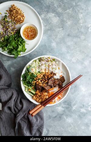 Ciotola di insalata tradizionale vietnamita noodle - Bun Bo Nam Bo, con manzo, noodle di riso, erbe fresche, verdure sottaceto e salsa di pesce Foto Stock