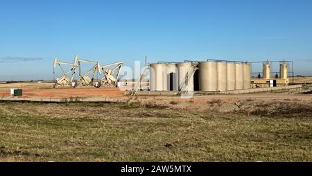 Nodding Donkey pompe in funzione, serbatoi di stoccaggio, Williston Basin Bakken Shale Oil Formation Region. Foto Stock