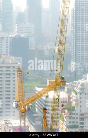 Veduta aerea di un cantiere con equipaggio di costruzione gru torre in un giorno torbido. Foto Stock