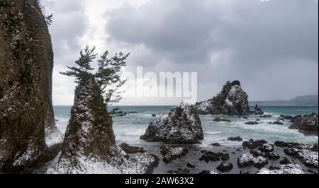 Una baracca e rocce sulla costa del Mare del Giappone nella Prefettura di Aomori, vista da un treno JR East sulla linea Gono. Foto Stock