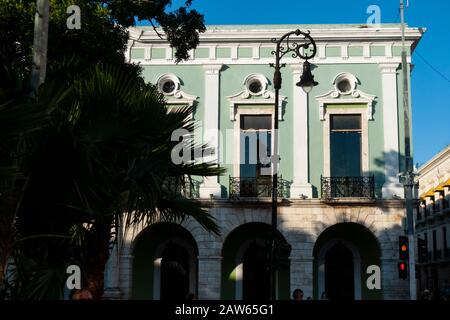Un lampione decorativo si trova contro la facciata verde del Palazzo del Governatore in Plaza de la Independencia Merida, Yucatan, Messico. Foto Stock