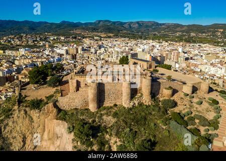 Veduta aerea della medievale onda parzialmente restaurato castello medievale rovina in Spagna con pareti concentriche, torri semi-circolari, interno ed esterno bailey Foto Stock