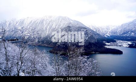Hallstatt sogno paesaggio inverno neve montagna paesaggio avventura all'aperto con cielo blu e pino in primo piano in giorno di neve, Austria Foto Stock