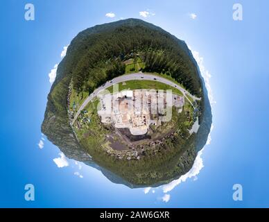 Veduta aerea del cantiere durante la costruzione di una casa di legno da travi spesse di alberi segati con attrezzature, trattori e camion. VR completo Foto Stock