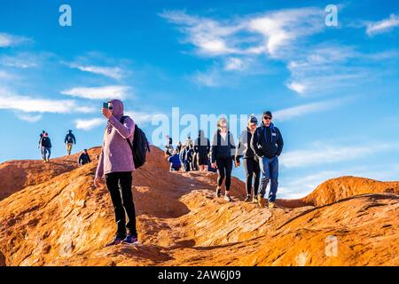 I turisti si arrampicano sul ripido terreno ondulato sulla cima di Uluru. Northern Territory, Australia Foto Stock