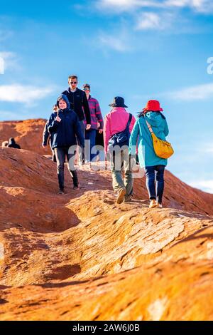 I turisti si arrampicano sul ripido terreno ondulato sulla cima di Uluru. Northern Territory, Australia Foto Stock