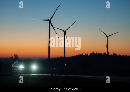 Winterbach, Germania. 07th Feb, 2020. All'alba, un'auto passa davanti a tre turbine eoliche. Credito: Sebastian Gollnow/Dpa/Alamy Live News Foto Stock