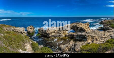Le correnti dell'Oceano meridionale si infrangono sulla baia rocciosa dell'isola di Rottenst creando archi rocciosi e grotte di scogliere marine. Foto Stock