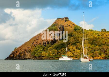 Barche ancorate all'isola di Pigeon con forte rovina sulla roccia, Rodney Bay, Santa Lucia, Mar dei Caraibi Foto Stock